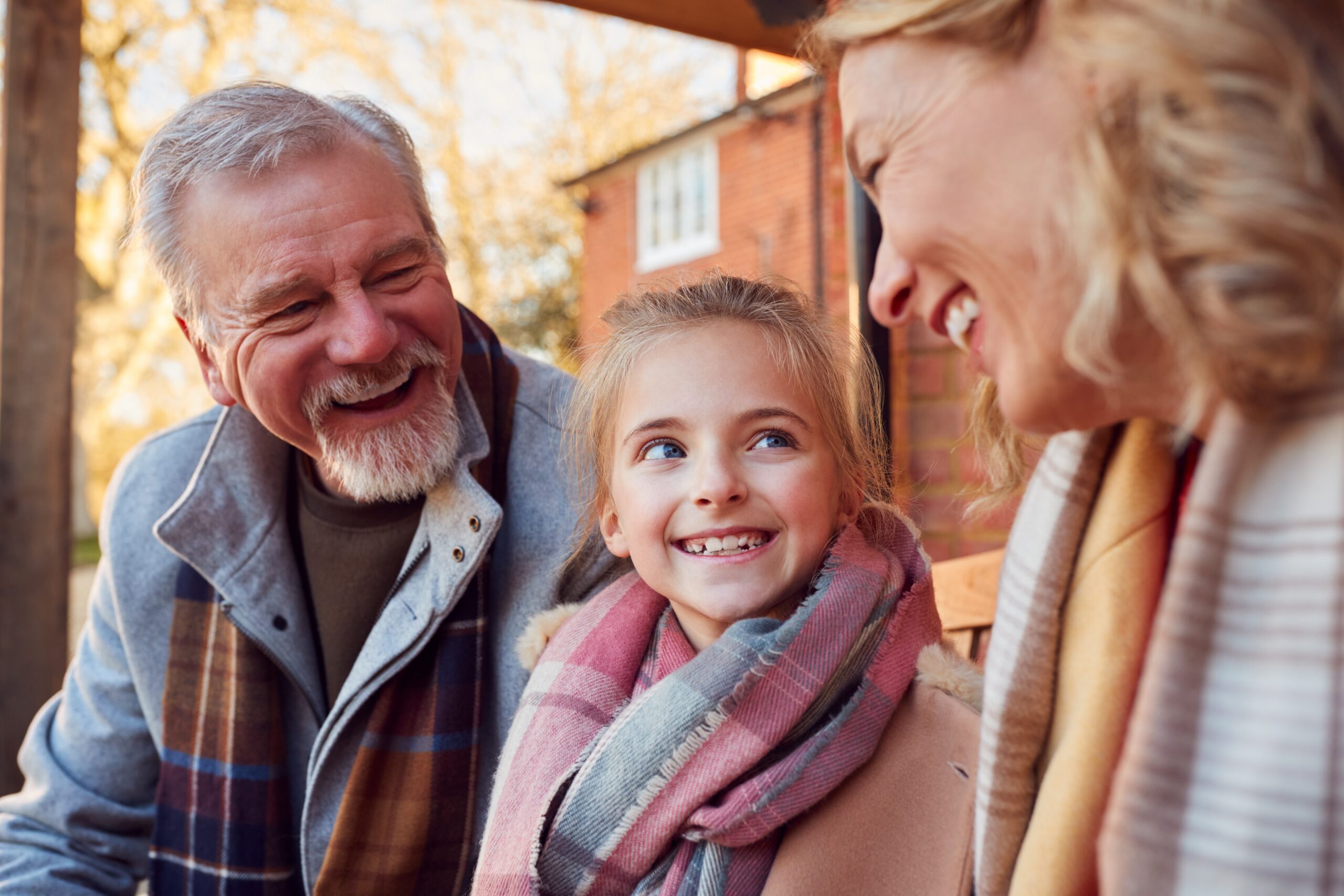Grandparents,With,Granddaughter,Outside,House,Getting,Ready,To,Go,For